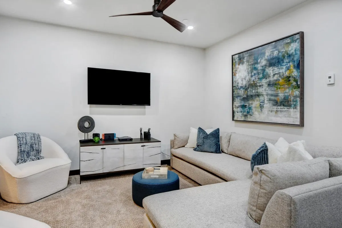 A cozy lower-level living room with a comfortable sofa, a modern coffee table, a large TV, and inviting decor. The space is designed for relaxation and socializing, with ample room for movie nights or unwinding after outdoor adventures.